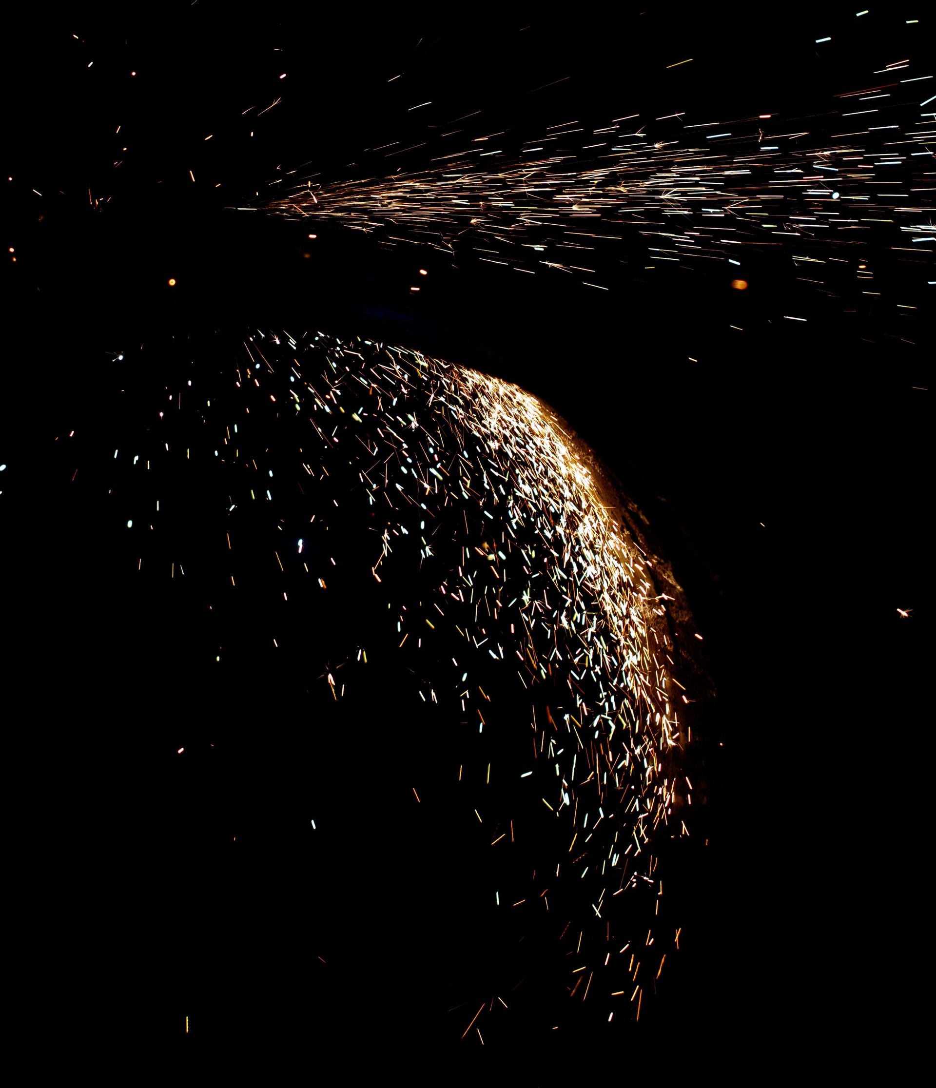 A black and white photo of a glowing sphere with a lot of sparks